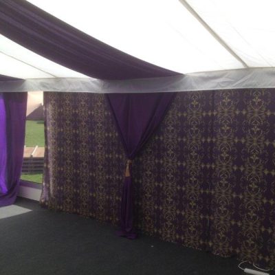 Brunel wall linings in purple and gold contrast with white ceiling linings in a marquee