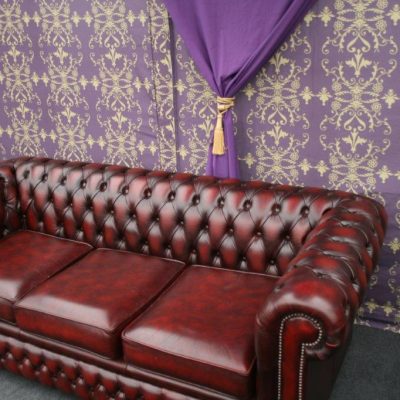 A Chesterfield sofa n front of a Brunel wall lining inside a marquee with grey carpet
