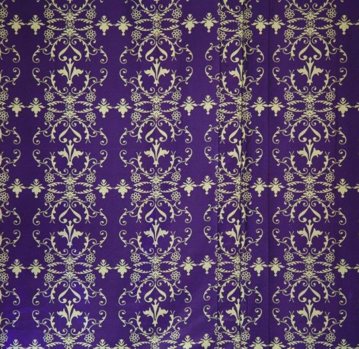 A close up of the detailed gold pattern on a purple backdrop of the Brunel marquee wall lining