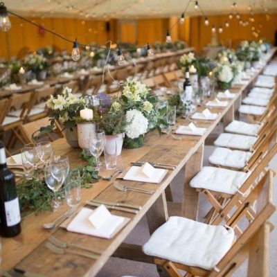 Wooden tables with saffron yellow linings for hire on the walls and ivory linings on the ceiling