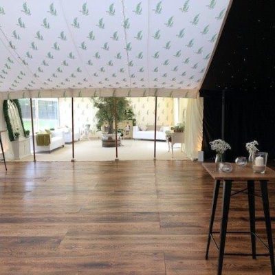 A marquee dancefloor with bespoke printed linings overhead and a sun filled chill out area beyond