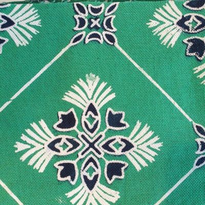 A block printed design on a marquee wall lining with white accents on a green background