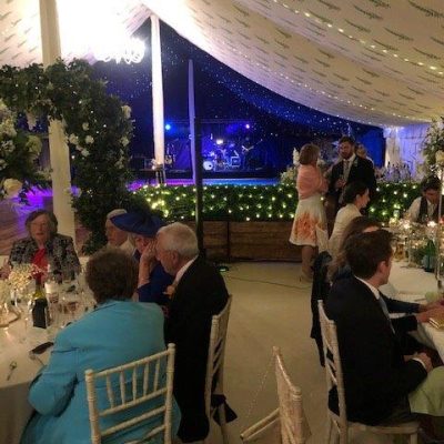 A marquee dining room with bespoke printed linings overhead and the dance foor beyond