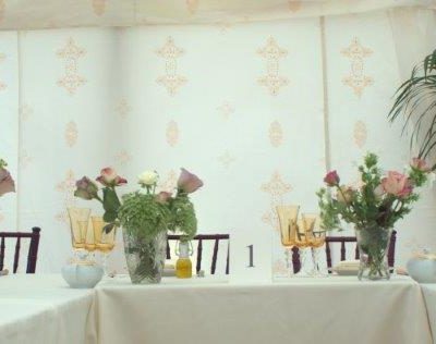 A landscape image of the wedding breakfast featuring Jasmine marquee linings as the backdrop and parlour palm