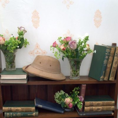 Jasmine marquee wall linings behind a book case with books flowers and hats as props