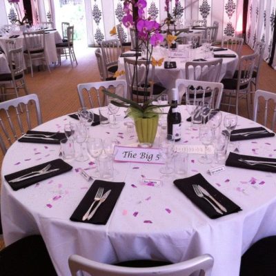 A marquee with black and white marquee walls, coconut matting and pith pink highlights