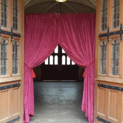 Velvet drapes create the party entrance at a historic venue with large wooden doors