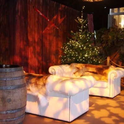A themed ski themed marquee party with beautiful lighting on a ski themed corner featuring wood plank wall linings in the background