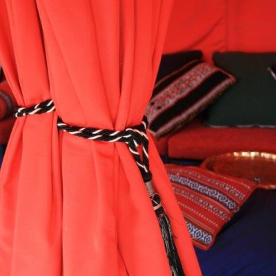 A Scarlet curtain tied back with black and red rope dresses the entrance to this party