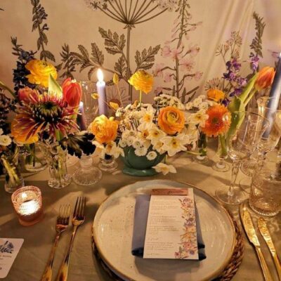 Candles lit at a styled individual place setting with a Botanical background